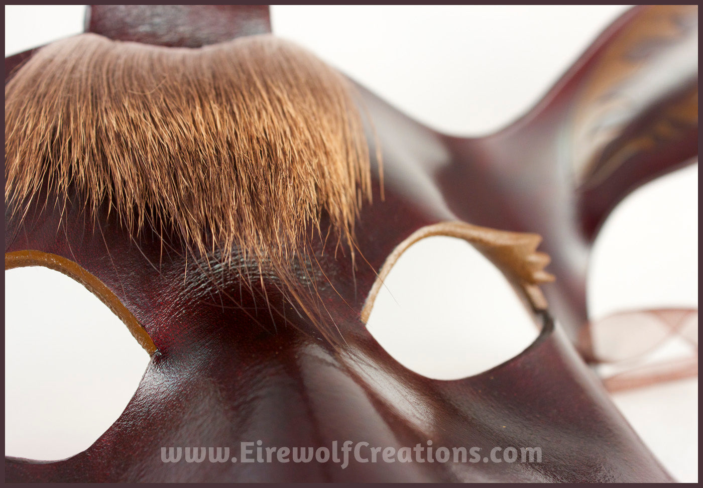The Dark Forest Unicorn is a dark brown handmade leather masquerade mask of a deerlike unicorn with real deer hair as a forelock. Detail view. By Erin Metcalf of Eirewolf Creations.