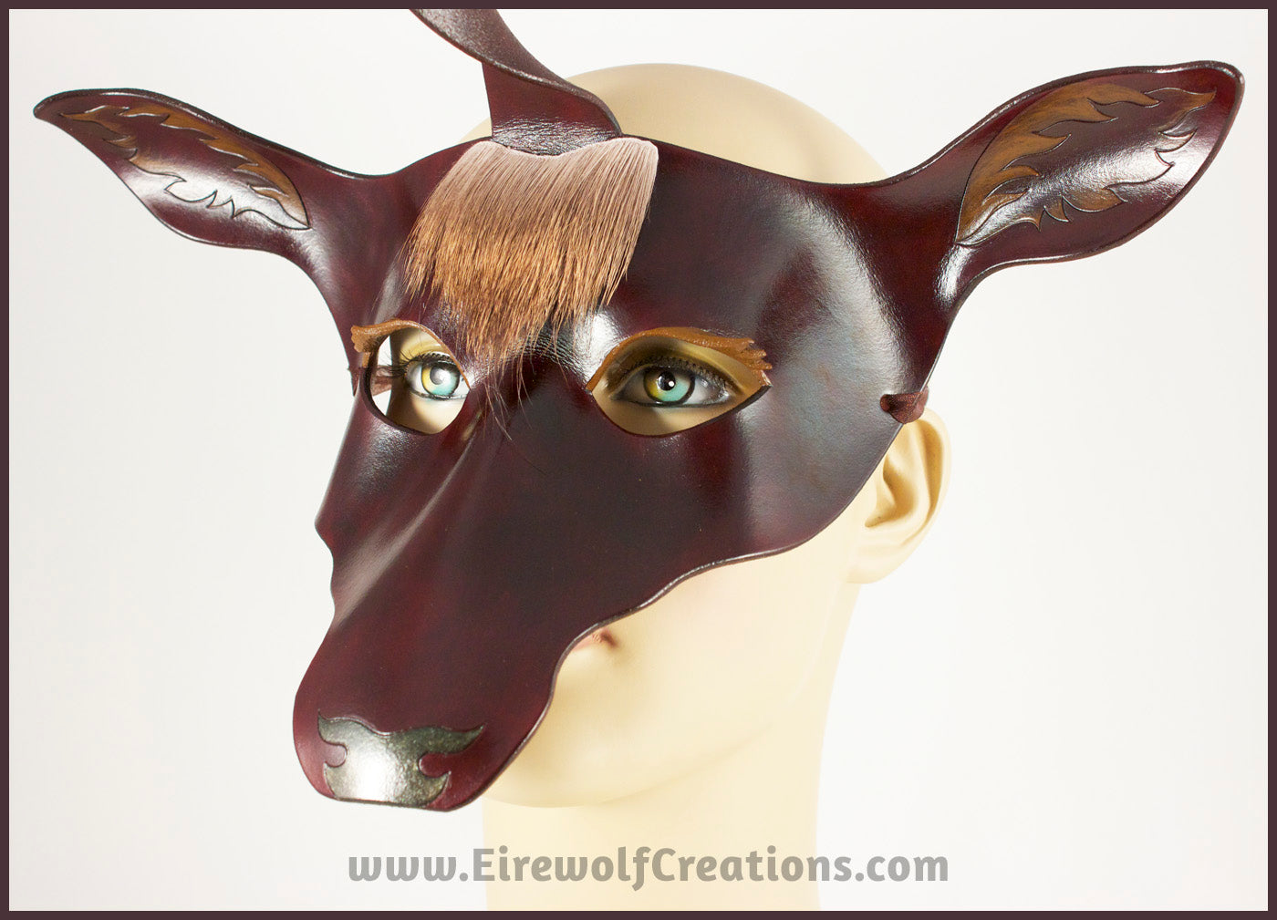 The Dark Forest Unicorn is a dark brown handmade leather masquerade mask of a deerlike unicorn with real deer hair as a forelock. By Erin Metcalf of Eirewolf Creations.