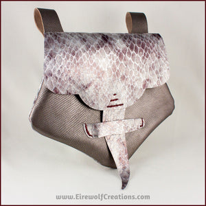 Handmade leather belt pouches in a medieval style with a scaled dragon skin texture, in purple or silver colors. By Erin Metcalf of Eirewolf Creations.