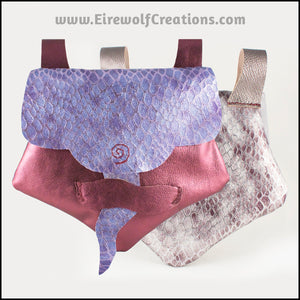 Handmade leather belt pouches in a medieval style with a scaled dragon skin texture, in purple or silver colors. By Erin Metcalf of Eirewolf Creations.