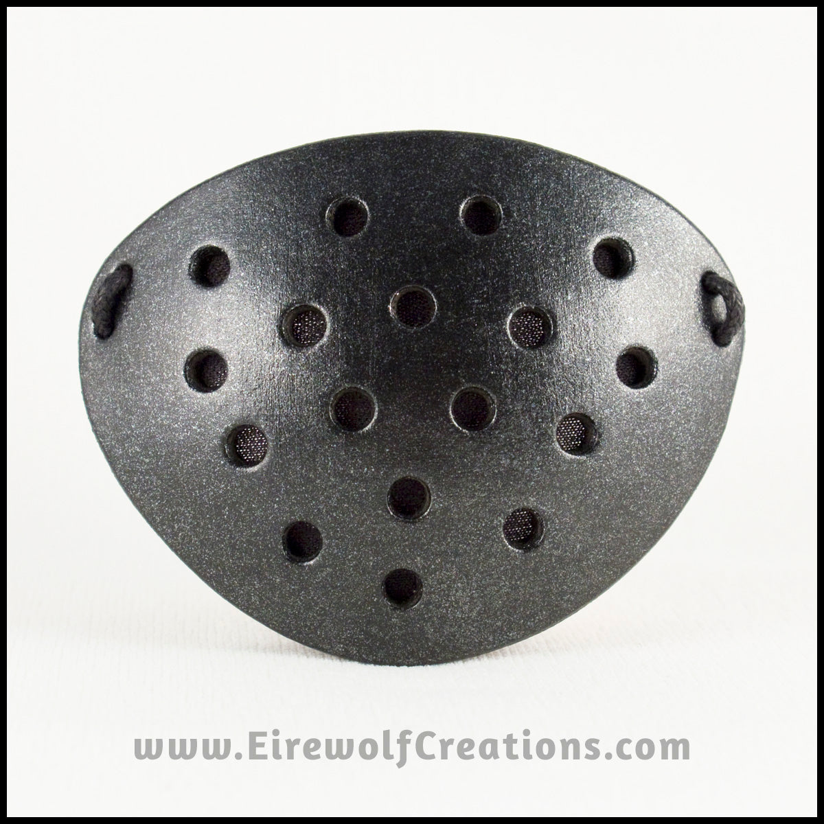 A handmade leather industrial style costume eye patch with 19 holes punched in it to allow some visibility, painted subtly sparkly black and backed with transparent black fabric. By Erin Metcalf of Eirewolf Creations.