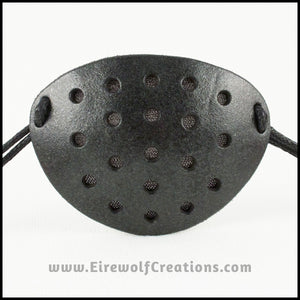 A handmade leather industrial style costume eye patch with 19 holes punched in it to allow some visibility, painted subtly sparkly black and backed with transparent black fabric. By Erin Metcalf of Eirewolf Creations.