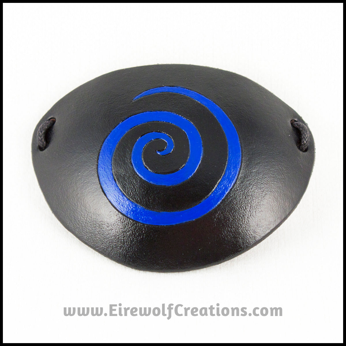 A handmade black leather eye patch with a carved and painted cobalt blue spiral, for a masquerade costume or pirate cosplay. By Erin Metcalf of Eirewolf Creations.
