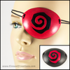 Handmade leather eye patches with a chunky Burtonesque spiral carved and painted red and black, for a masquerade costume or pirate cosplay. By Erin Metcalf of Eirewolf Creations.