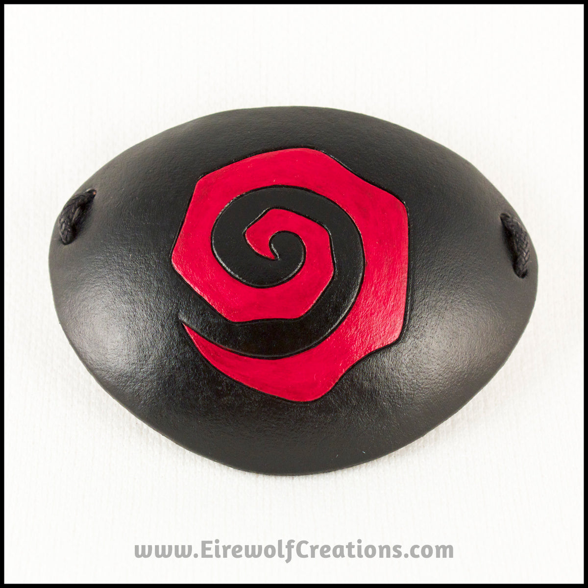 Handmade leather eye patches with a chunky Burtonesque spiral carved and painted red and black, for a masquerade costume or pirate cosplay. By Erin Metcalf of Eirewolf Creations.