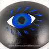 A bold graphic stylized blue eye with blue eyelashes carved and painted onto a handmade black leather eye patch, for a masquerade costume or pirate cosplay. By Erin Metcalf of Eirewolf Creations.