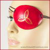 A handmade leather eye patch with a triquetra, or Celtic trinity knot, carved and painted copper on a dyed red background, for a masquerade costume or pirate cosplay. By Erin Metcalf of Eirewolf Creations.