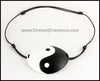 A handmade leather eye patch with a bold black and white yin yang symbol carved and painted over the whole eye patch, for a masquerade costume or pirate cosplay. By Erin Metcalf of Eirewolf Creations.