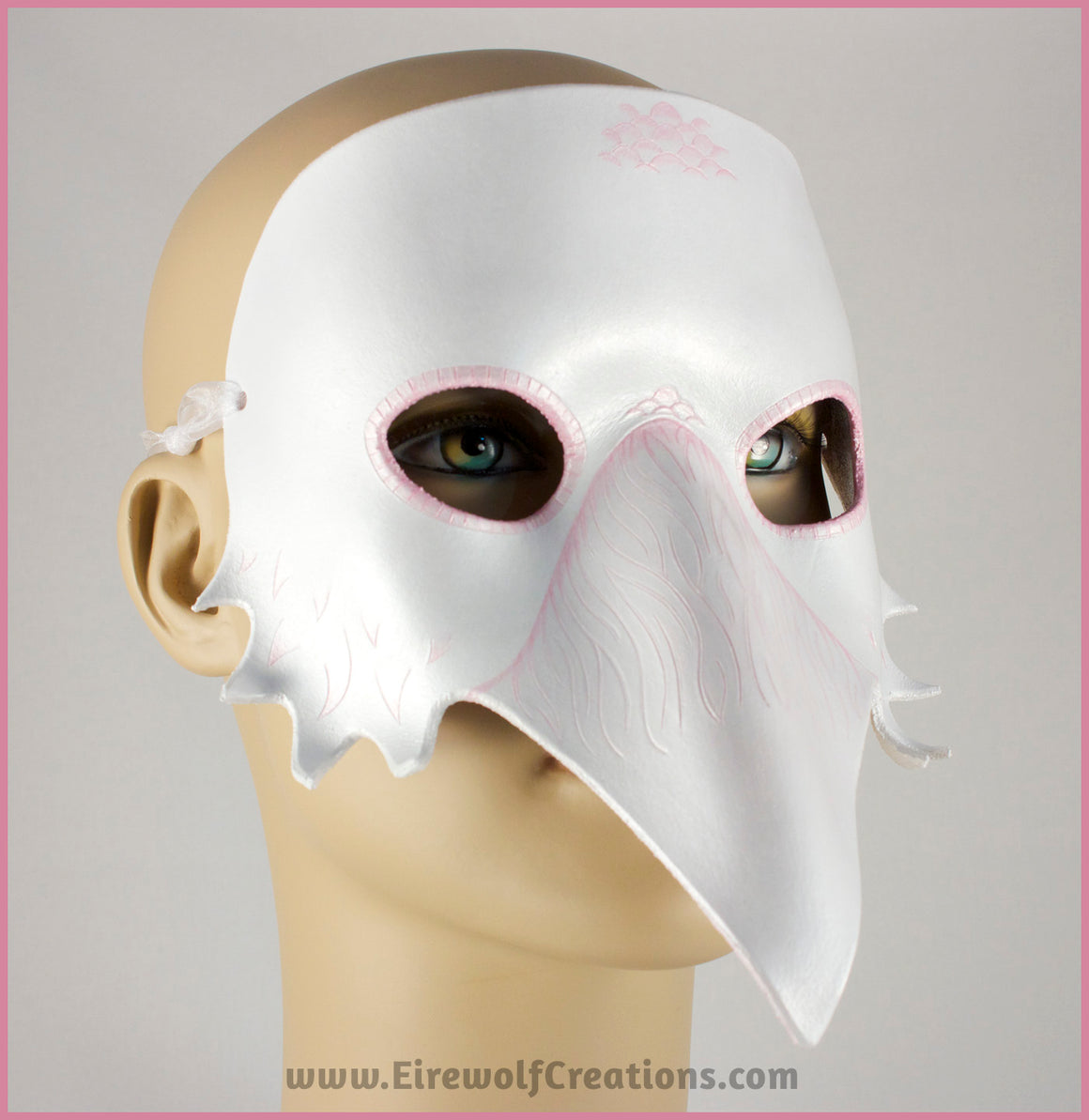 A handmade leather Albino Raven or White Crow mask for a masquerade costume, with carved and handpainted pale pink feather details. By Erin Metcalf of Eirewolf Creations.
