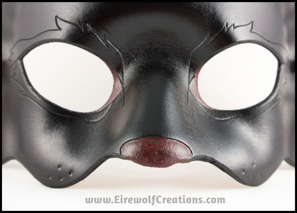 Detail of a handmade black cat leather masquerade mask with dark red nose and inner ears. By Erin Metcalf of Eirewolf Creations.