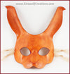 A handmade leather rabbit mask for a masquerade costume, dyed light brown with subtle red details painted around the eyes and nose. By Erin Metcalf of Eirewolf Creations.