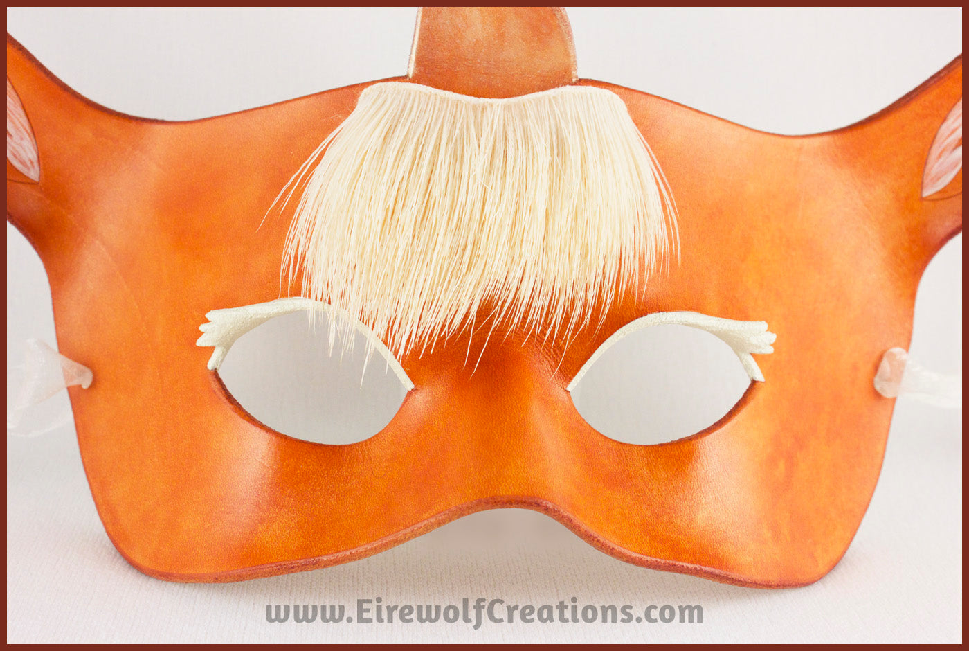 Closeup of a handmade leather palomino unicorn mask for a masquerade costume, with a twisting horn and cream-colored forelock made of real deer hair. By Erin Metcalf of Eirewolf Creations.