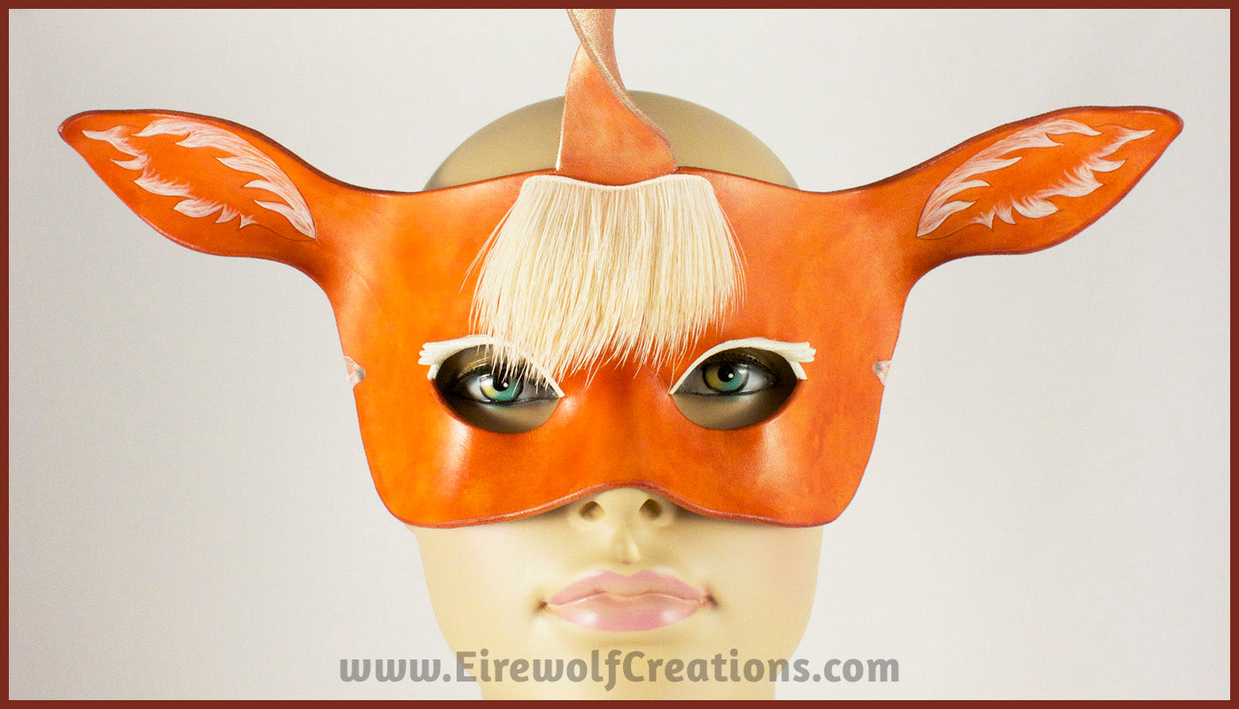 A handmade leather palomino unicorn mask for a masquerade costume, with a twisting horn and cream-colored forelock made of real deer hair. By Erin Metcalf of Eirewolf Creations.