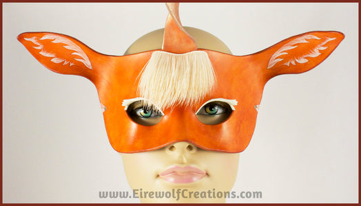 A handmade leather palomino unicorn mask for a masquerade costume, with a twisting horn and cream-colored forelock made of real deer hair. By Erin Metcalf of Eirewolf Creations.